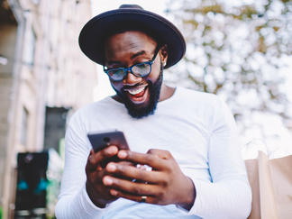 A customer looks happily at his smartphone.